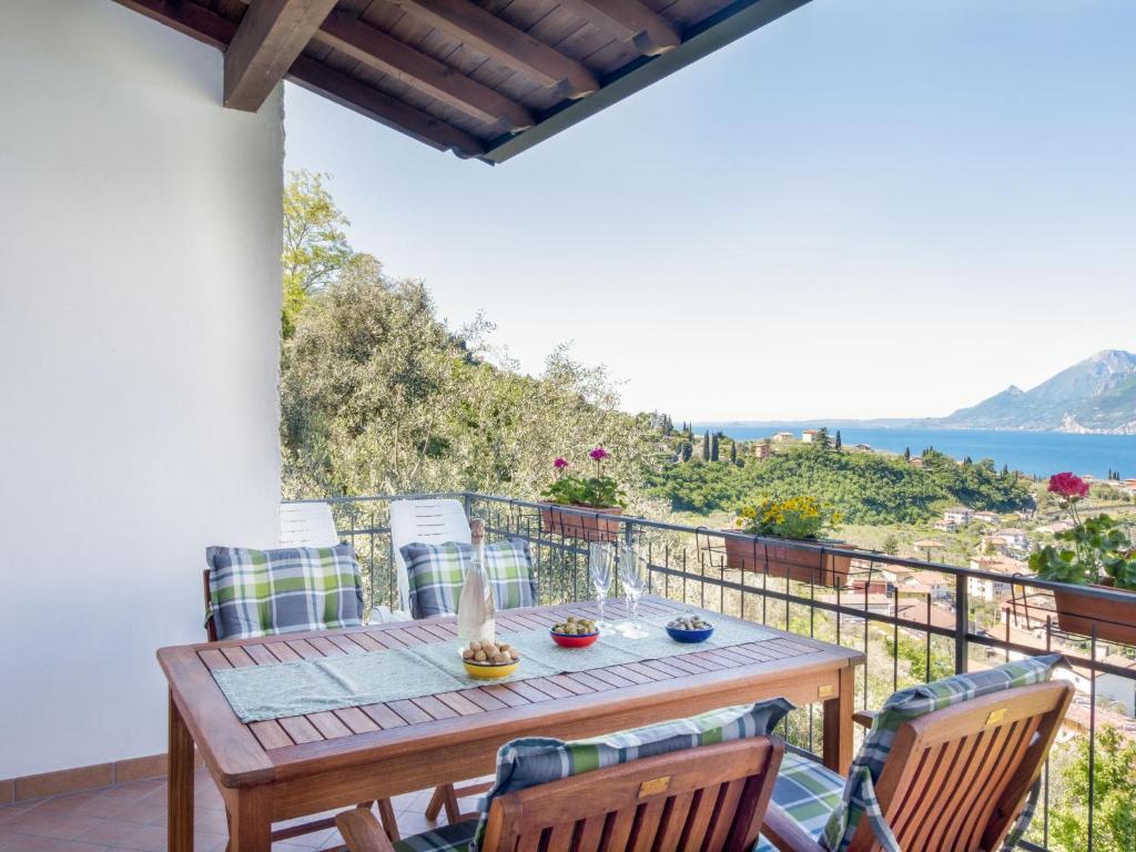 una mesa de madera en un balcón con vistas al océano en Holiday Home Verdin by Interhome, en Malcesine
