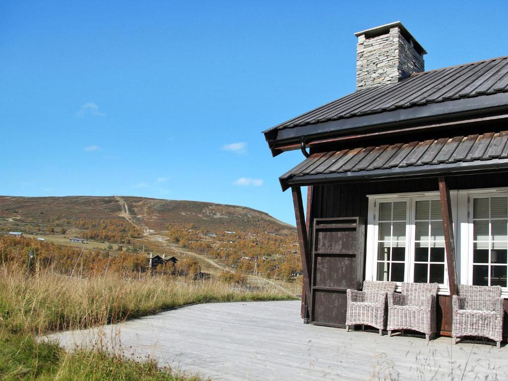 a house with two chairs sitting outside of it at Apartment Havsdalsgrenda - HLD102 by Interhome in Geilo