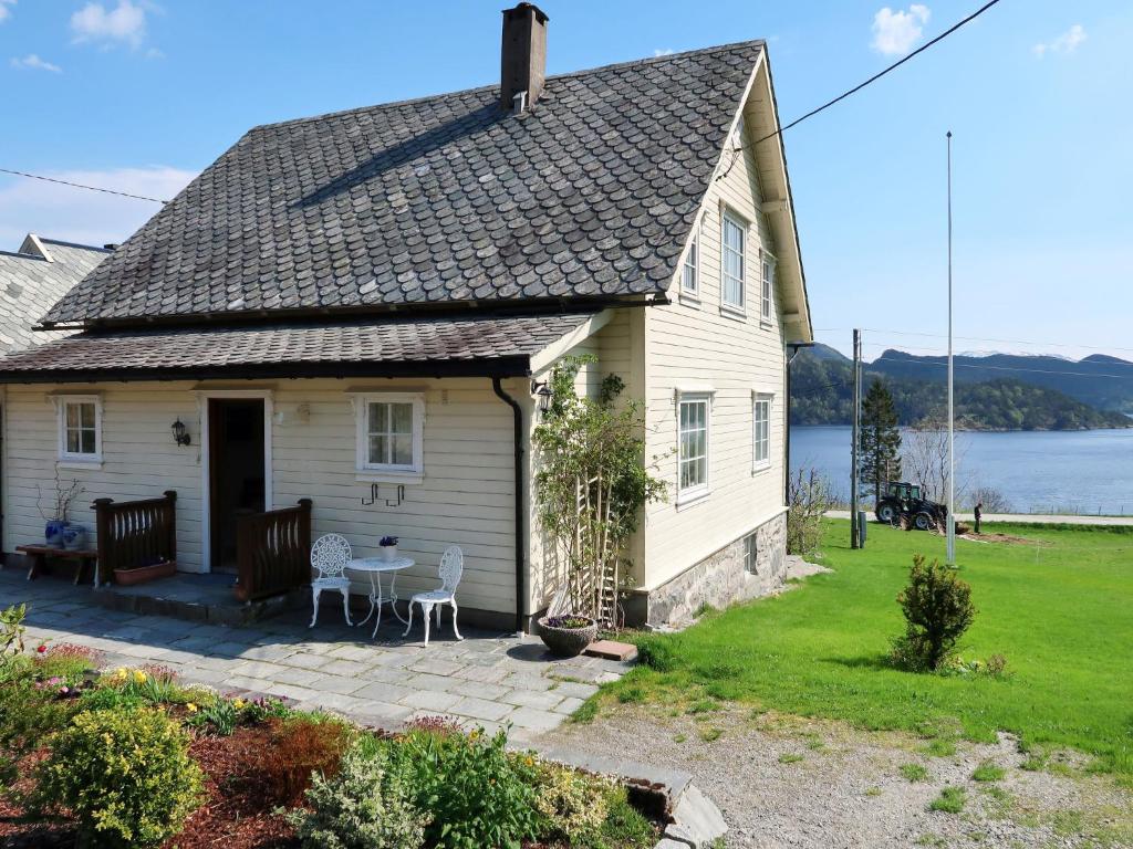 a house with a patio and a view of the water at Holiday Home Kvamsvika - FJS560 by Interhome in Kvammen