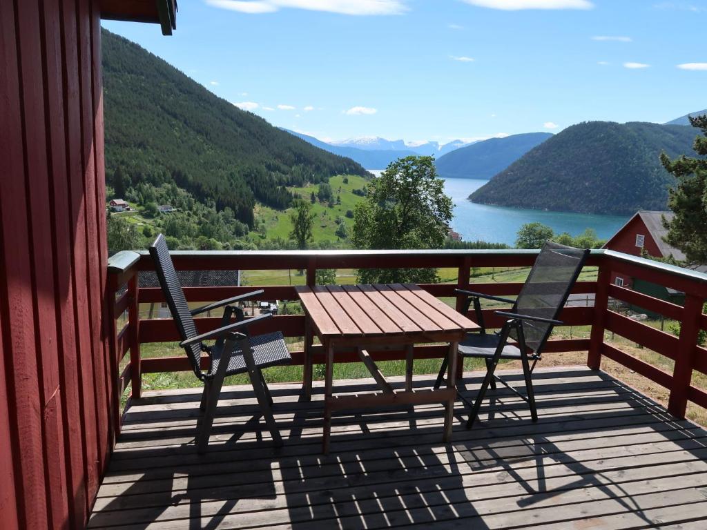 a table and two chairs on a deck with a view of a lake at Holiday Home Hammaren - FJS771 by Interhome in Kaupanger