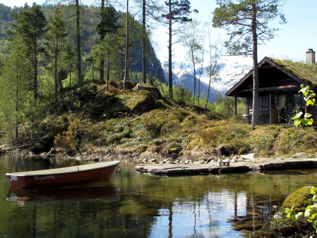 a small boat in the water next to a house at Holiday Home Lauvavatnet - FJS087 by Interhome in Viksdalen