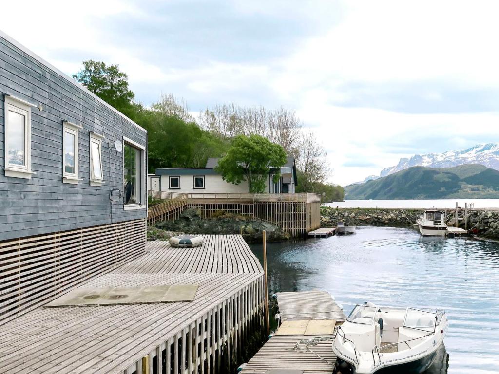 a boat is docked on a dock next to a house at Holiday Home Kyrkjestein - FJS556 by Interhome in Naustdal i Sunnfjord