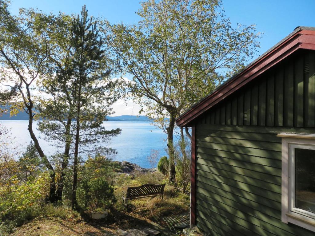 un banco junto a un edificio con vistas al lago en Holiday Home Hjartnesvika - FJH662 by Interhome, en Hjartåker