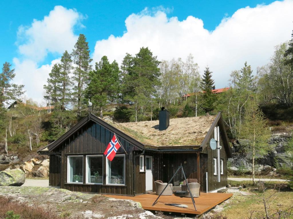 a small house with a flag on the roof at Holiday Home Utsikten - SOW134 by Interhome in Tjaldal