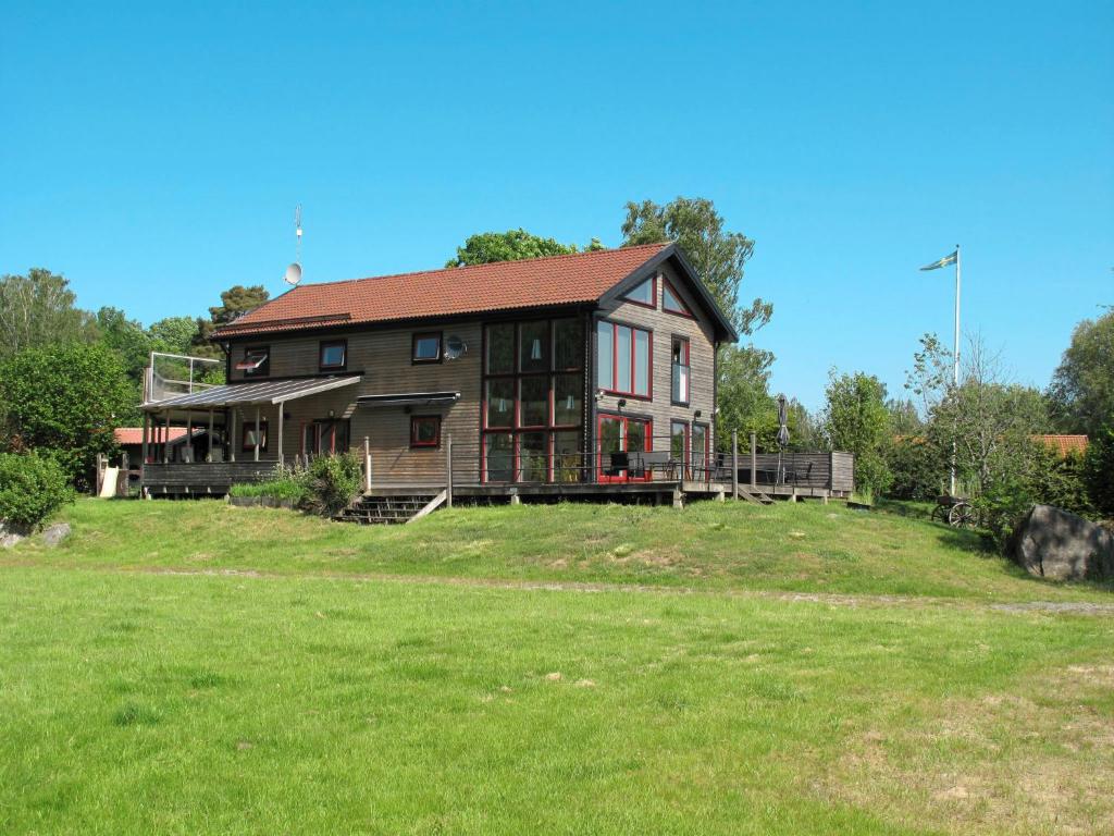 a large house on a hill with a grass field at Holiday Home Hoka Villan - B in Asarum