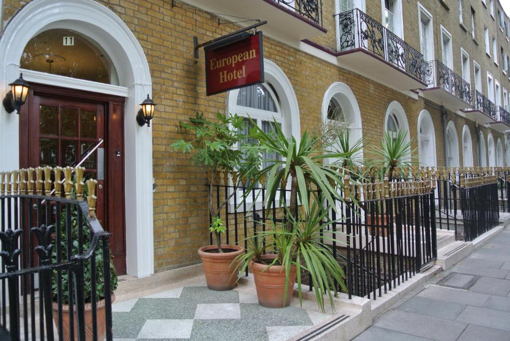 a building with potted plants in front of a building at European Hotel in London