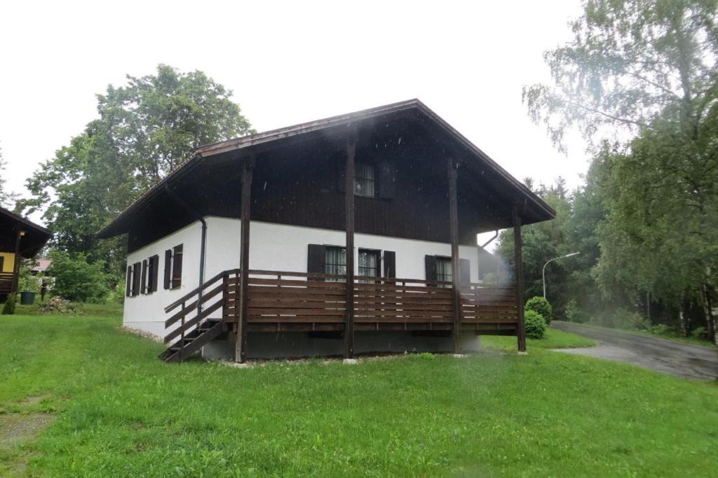 a cabin with a gambrel roof on a grass field at Ferienhaus Petra in Regen