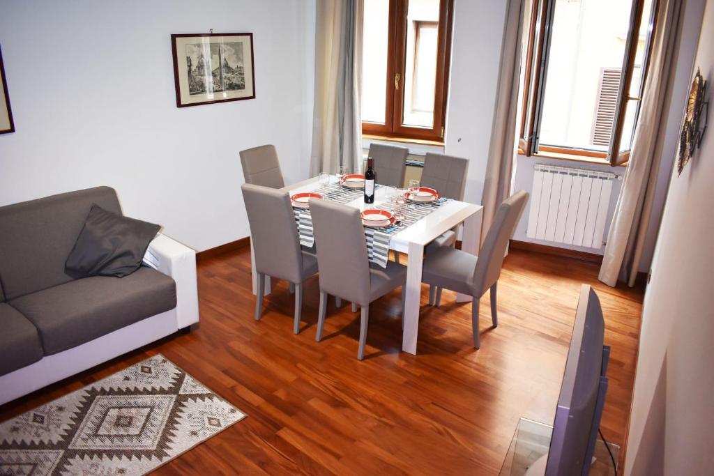 a dining room with a table and chairs and a couch at VG [VIA DEL CORSO 5 STELLE] Luxury apartment in Rome