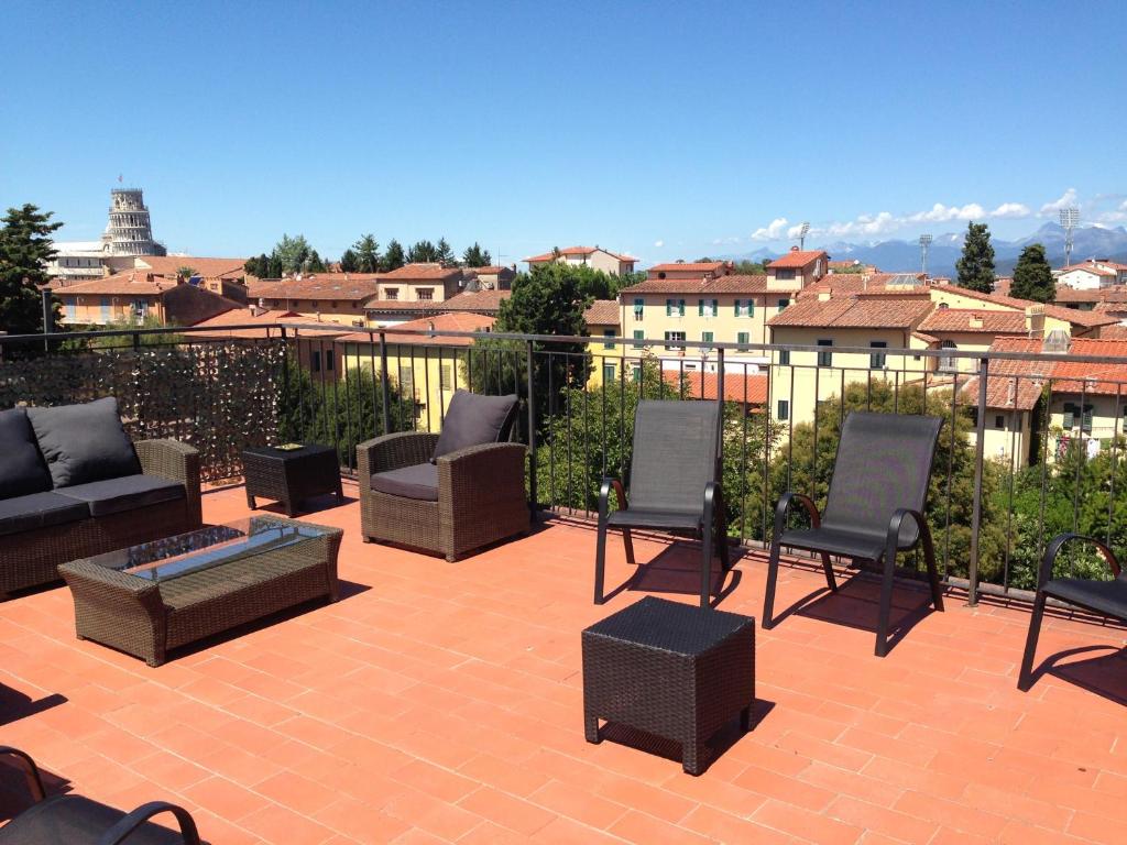 a patio with chairs and a couch and a fire pit at Hotel Di Stefano in Pisa