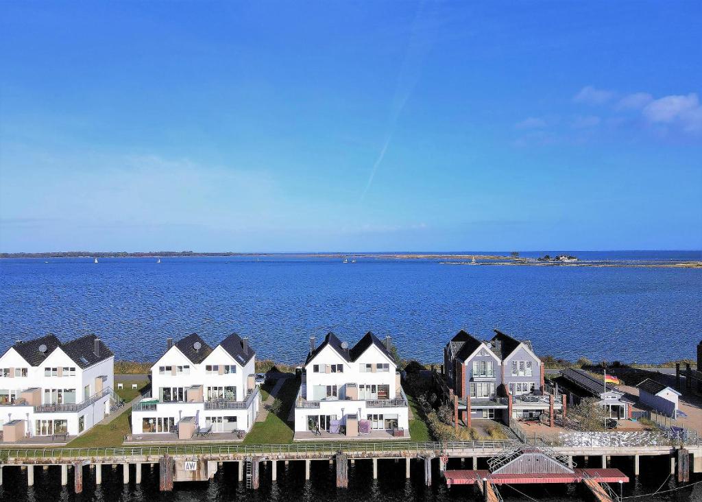 a group of houses on a pier next to the water at Brigantine 33 by Seeblick Ferien in Olpenitz