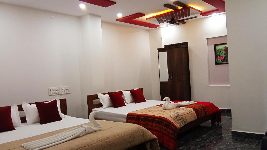 a bedroom with two beds with red and white pillows at Leo's Residency Coorg in Kushālnagar
