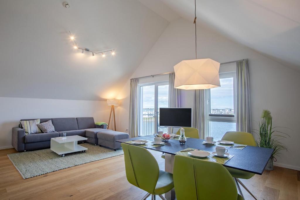 una sala de estar con una mesa y un sofá en Reeders Topp by Seeblick Ferien, en Olpenitz