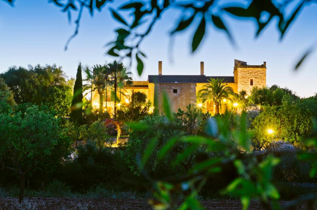 an old building with palm trees in the foreground at Principal Son Amoixa in Manacor