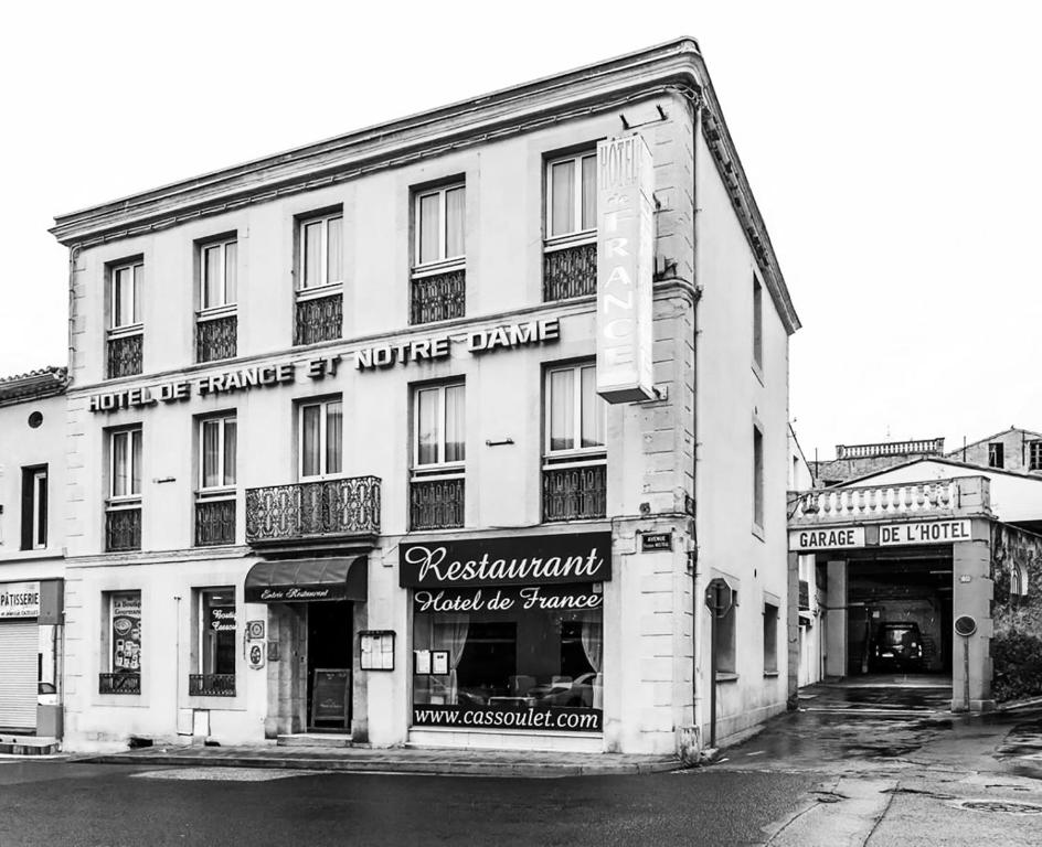 une photo en noir et blanc d'un bâtiment blanc dans l'établissement Hôtel Restaurant de France, à Castelnaudary