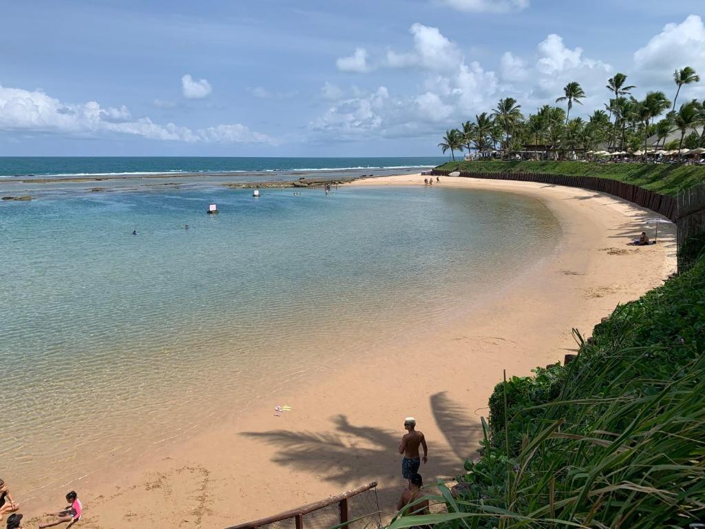 Ein Mann steht am Strand neben dem Meer in der Unterkunft Nannai Residence Flat - Muro Alto in Porto De Galinhas