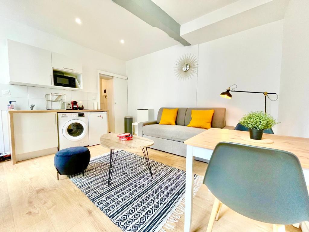 sala de estar con sofá y mesa en Rouen - Appartements - Centre Historique - Tout Confort - Internet Fibre en Rouen