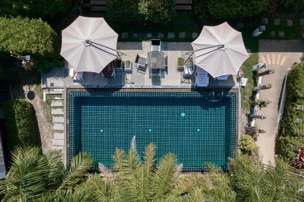 Vue aérienne d'une piscine avec deux parasols dans l'établissement The Loft Panwa Resort, à Panwa Beach