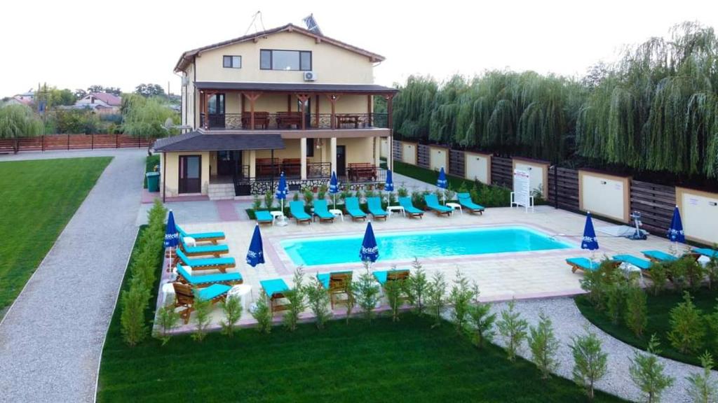 a house with a swimming pool and blue chairs at Casa Vlad in Murighiol