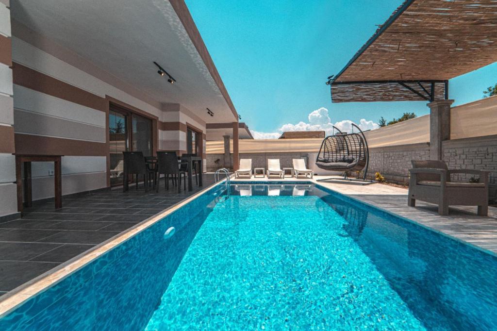 a swimming pool in front of a house at Orange Blossom villas in Fethiye