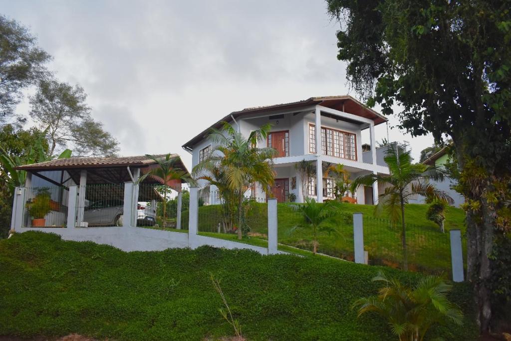 una casa bianca con una recinzione di fronte di Casa Espetacular no Centro da Serra a Nova Friburgo