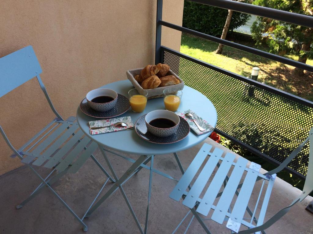 una mesa con una bandeja de pan y dos sillas en Helvétia, en Thonon-les-Bains