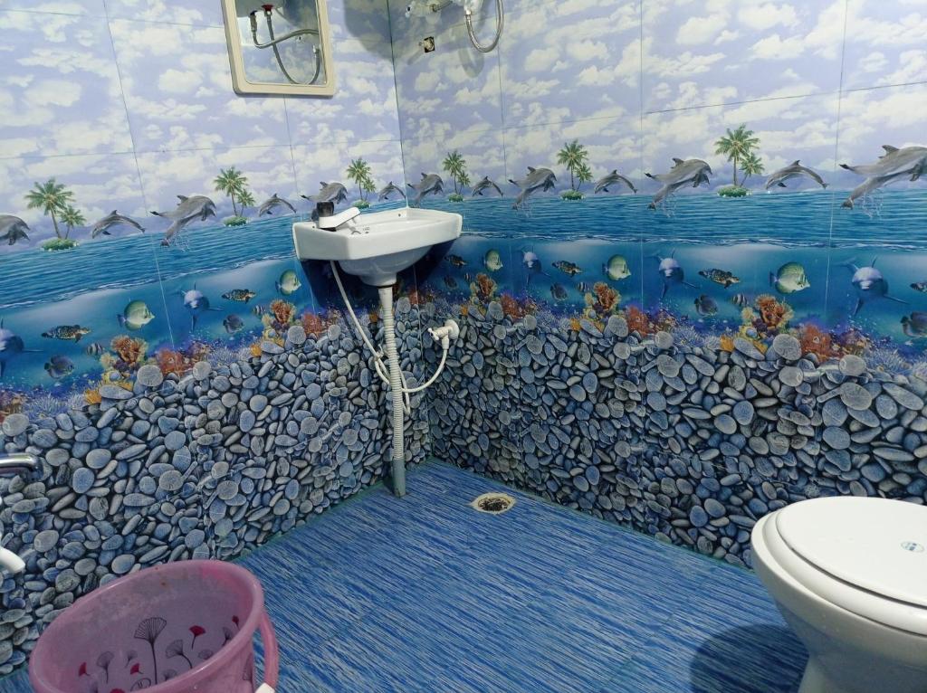 a bathroom with a sink and a fish themed wall at Dreams River view homestay coorg B in Kushālnagar