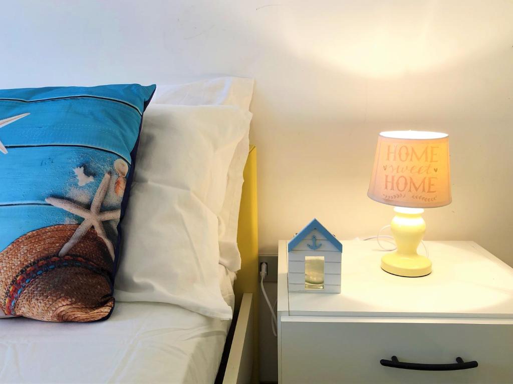 a bed with a pillow and a lamp with a home i wanna have at Apartment Malta in Alghero