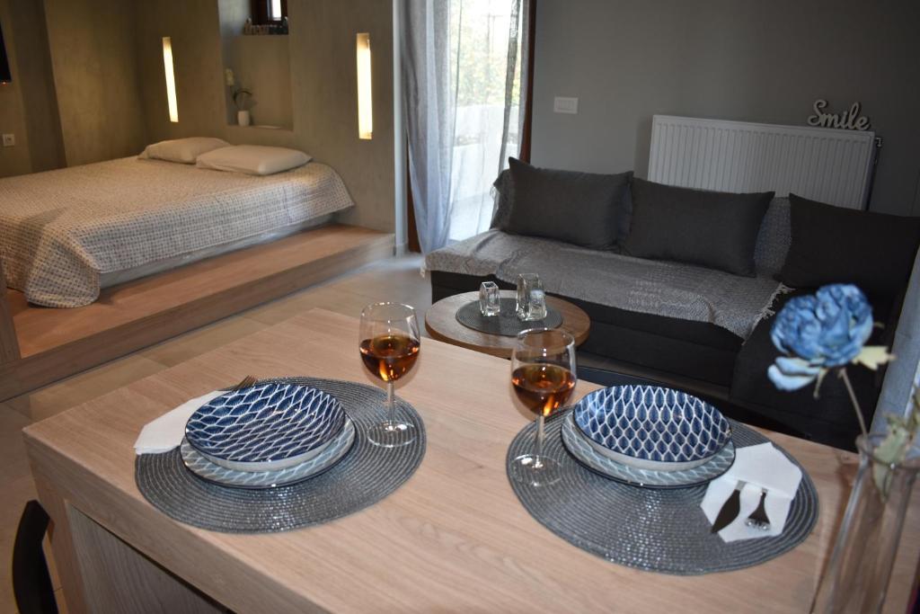 un soggiorno con tavolo e 2 bicchieri di vino di Saxon's Apartment a Chania