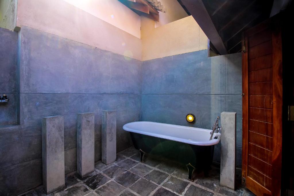 a bathroom with a bath tub in a room at Palm Paradise Cabanas & Villas Beach Resort in Tangalle
