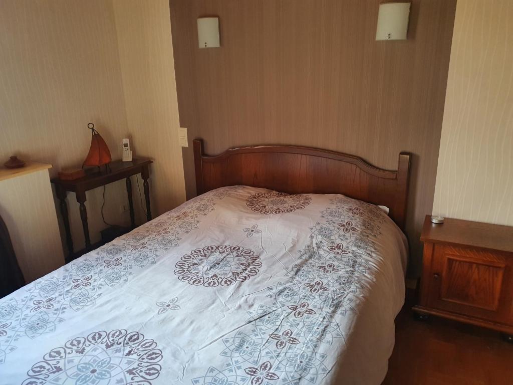 um quarto com uma cama com um edredão branco em Maison dans un village calme em Carla-de-Roquefort