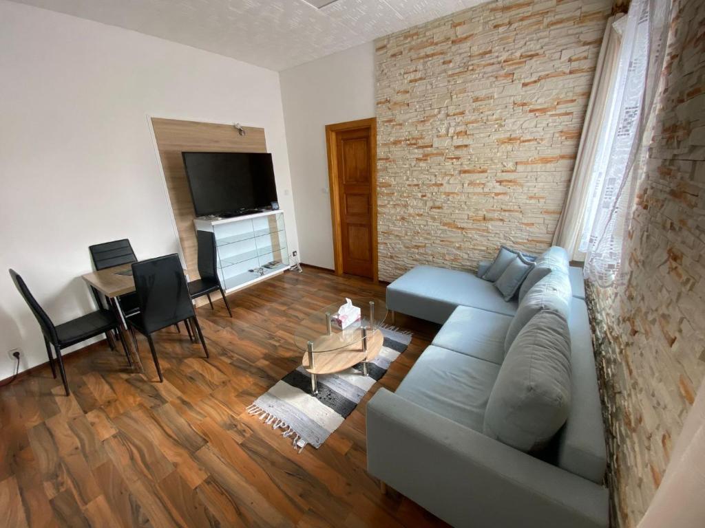 a living room with a couch and a brick wall at Apartment Hlinská in České Budějovice