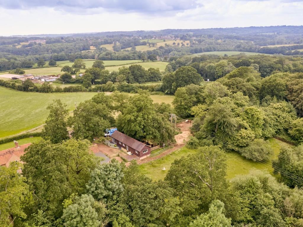 an aerial view of a farm with a barn and trees at Forest Farm Cottage in Haywards Heath