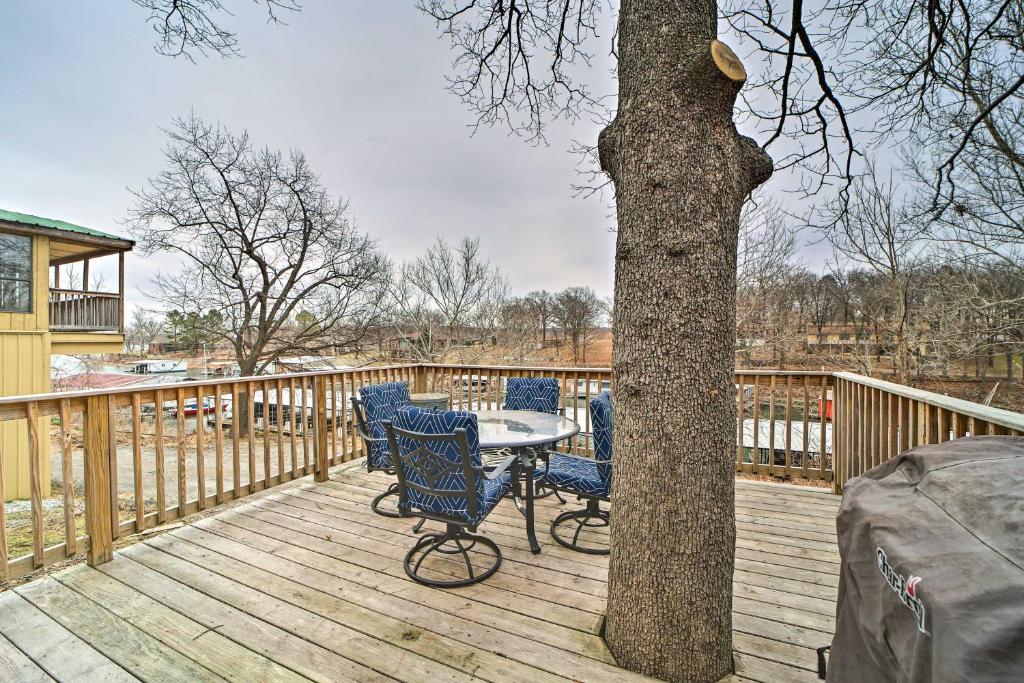 einen Tisch und Stühle auf einer Terrasse neben einem Baum in der Unterkunft Lakefront Eucha Escape with Views and Boat Slip! in Eucha