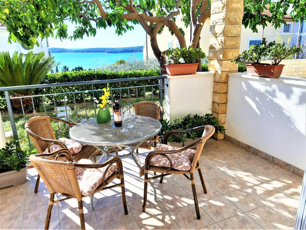 een tafel en stoelen op een patio met uitzicht op het water bij Apartments Tamara in Hvar