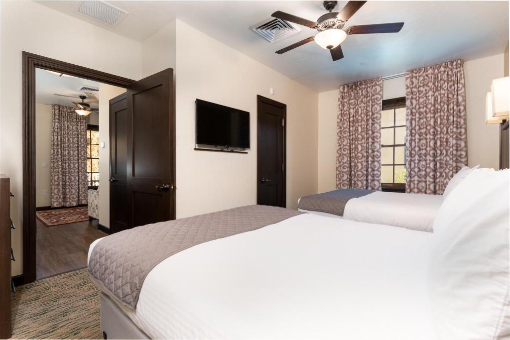 a bedroom with two beds and a flat screen tv at The Ranch At Death Valley in Indian Village