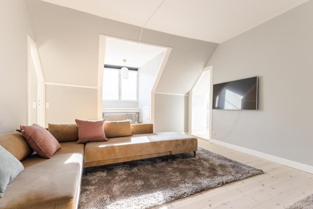 een woonkamer met een bank en een tv bij Luxury Apartment w Privat Rooftop Terrace - CPH C in Kopenhagen