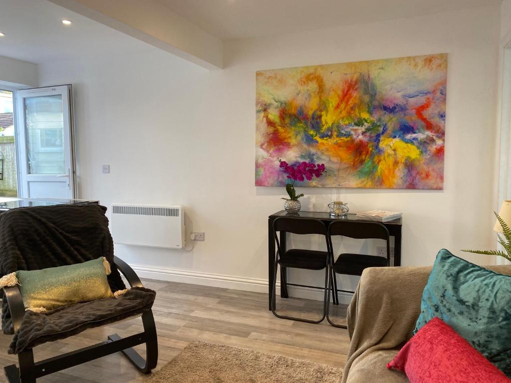 a living room with a painting hanging on the wall at Coastal Retreat in Brightlingsea