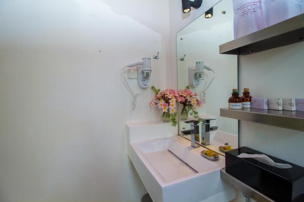 a bathroom with a sink and a mirror at Palm Paradise Cabanas & Villas Beach Resort in Tangalle