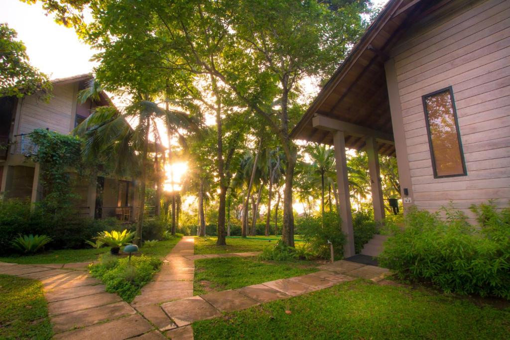 a house with a yard with trees and grass at Palm Paradise Cabanas & Villas Beach Resort in Tangalle