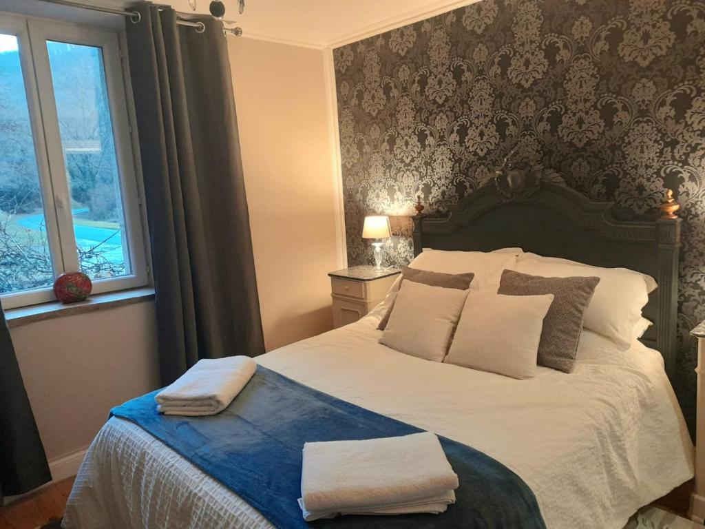 1 dormitorio con 1 cama con 2 toallas en Les Roches Restaurant & Chambre d'Hotes, en Servant
