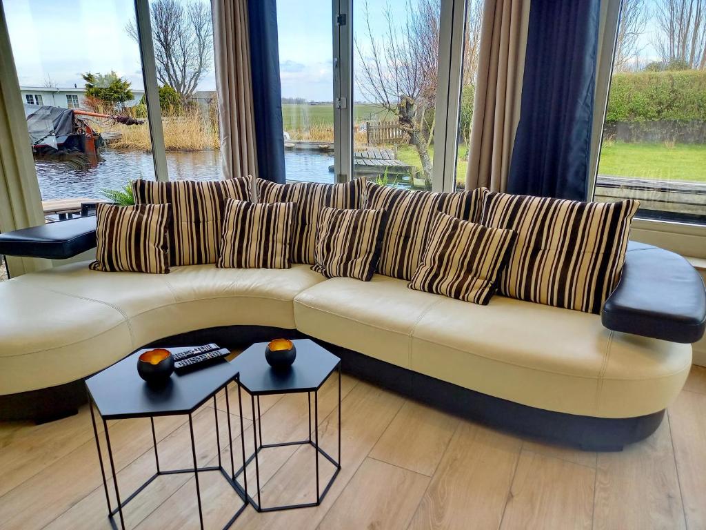 Pura Vida del Rio في Oud-Ade: أريكة في غرفة معيشة مع نافذة كبيرة