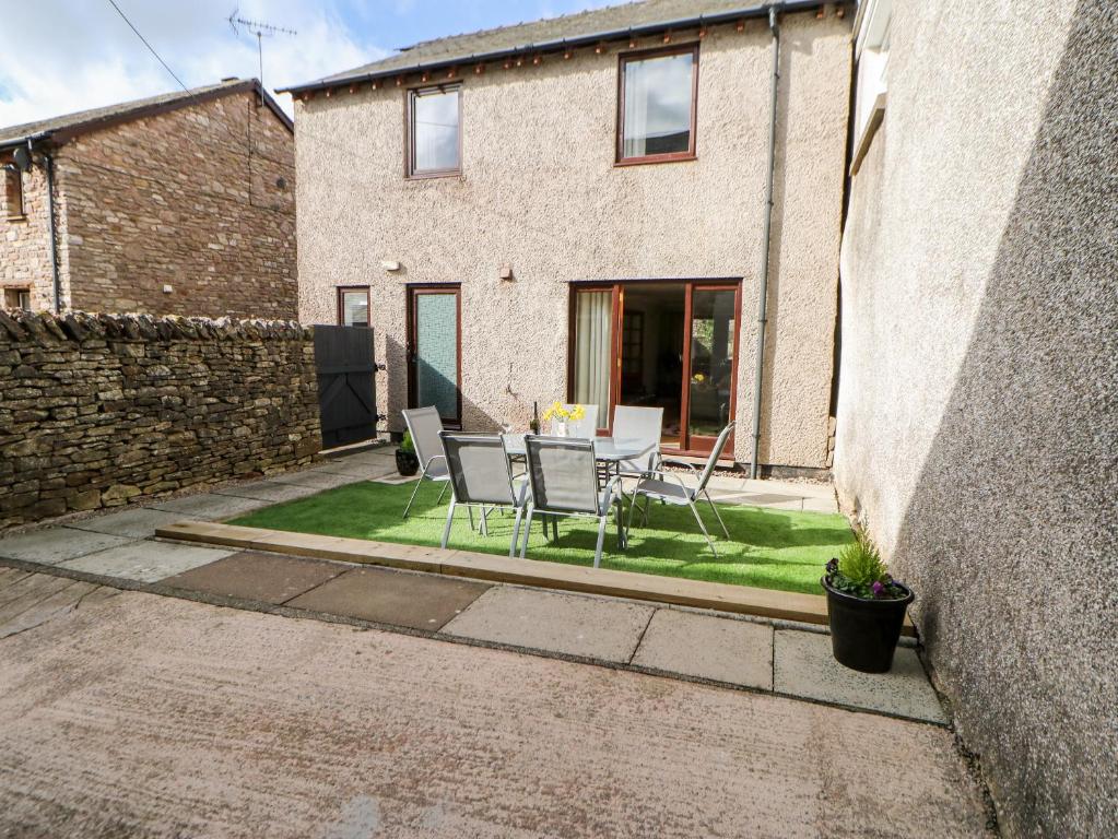 a patio with a table and chairs in front of a building at Summerseat in Kirkby Stephen