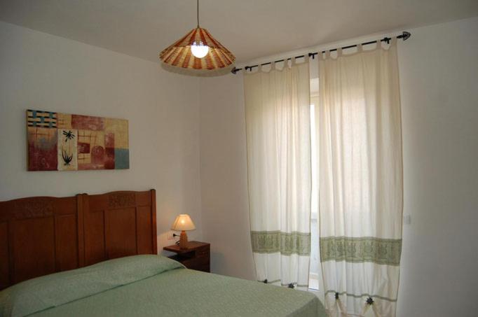 sypialnia z łóżkiem i dużym oknem w obiekcie C'e Posto Per Te w mieście SantʼAntìoco