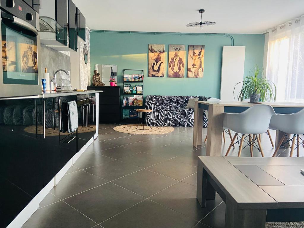 沙勒維爾－梅濟耶爾的住宿－Les Perdrix，厨房拥有蓝色的墙壁,配有桌椅