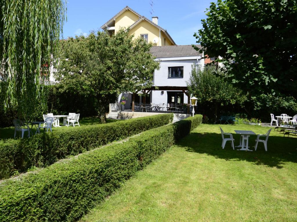 a garden with tables and chairs in front of a house at Hotel Les Terrasses in Annecy