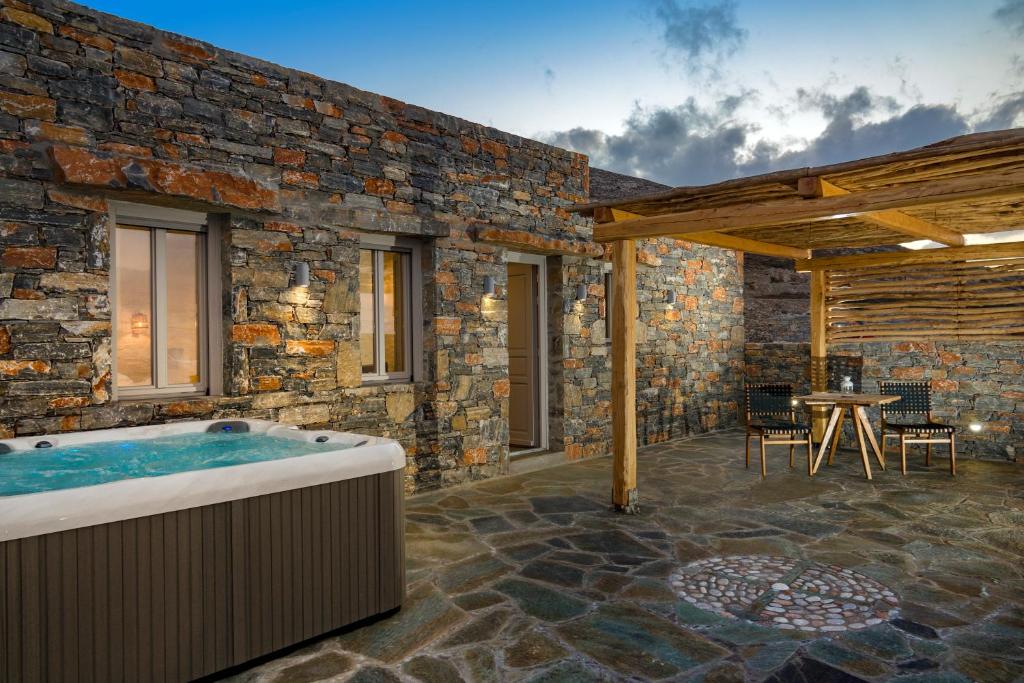 ein Steinhaus mit einem Whirlpool auf der Terrasse in der Unterkunft Maris Private Residence in Folegandros Chora