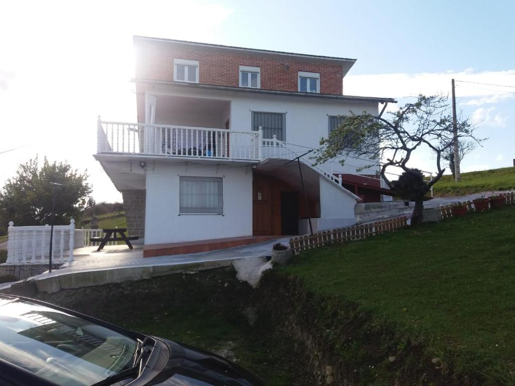 a house with a car parked in front of it at Apartamentos Santillán in San Vicente de la Barquera