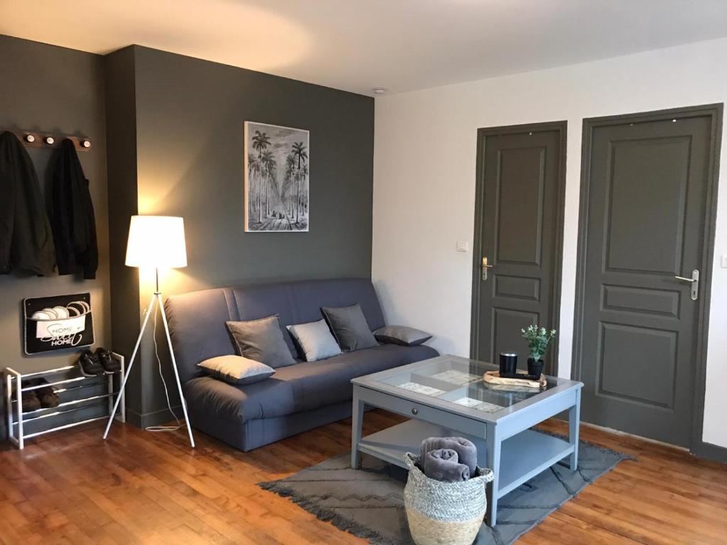 - un salon avec un canapé et une table dans l'établissement Logement à Brive, proche centre-ville et gare, avec Netflix - internet fibre - Stationnements gratuit, à Brive-la-Gaillarde