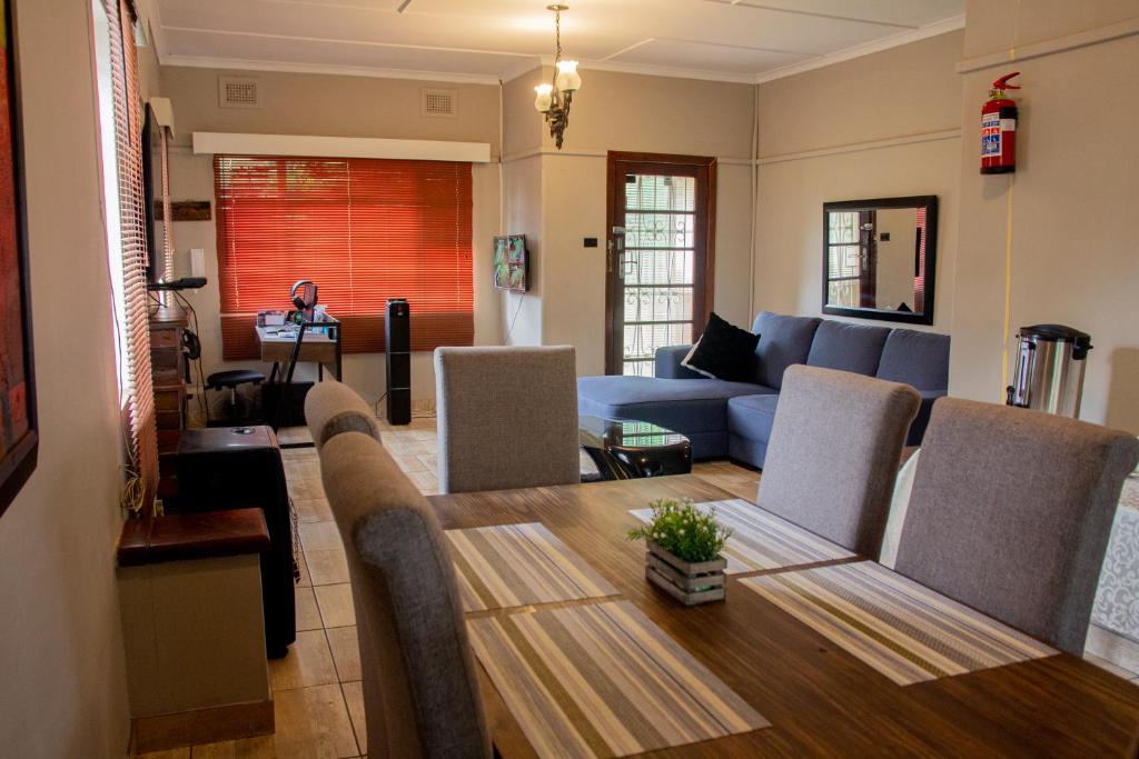 een woonkamer met een tafel en een blauwe bank bij BLUEBERRY BED AND BREAKFAST in Pietermaritzburg