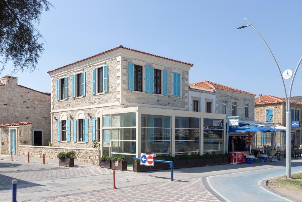 un edificio en una calle de la ciudad con una tienda en Marina Foça Hotel, en Foca